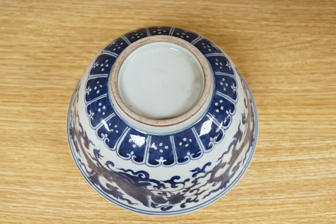 A Chinese porcelain bowl, painted with dragons in underglaze blue, 18cm diameter.